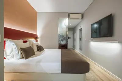 a bedroom with a large bed and a flat screen tv at King David Suites by Homie in Funchal