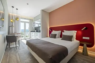 a bedroom with a large bed with a red headboard at King David Suites by Homie in Funchal