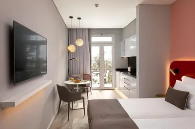 a bedroom with a bed and a table and a kitchen at King David Suites by Homie in Funchal