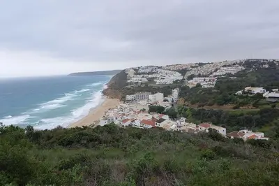 a group of houses on a hill next to the ocean at Bica da Salema Beach House in Salema