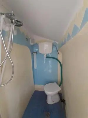 a small bathroom with a toilet and a shower at Bica da Salema Beach House in Salema