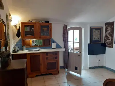 a kitchen with wooden cabinets and a sink and a window at Bica da Salema Beach House in Salema