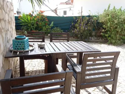 a wooden table with two chairs and a cake on it at Bica da Salema Beach House in Salema