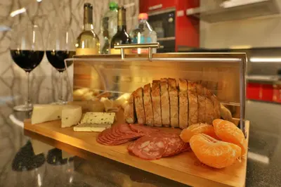 a cutting board with meat and cheese and wine glasses at Villa Leonor Cliffside Retreat in Calheta