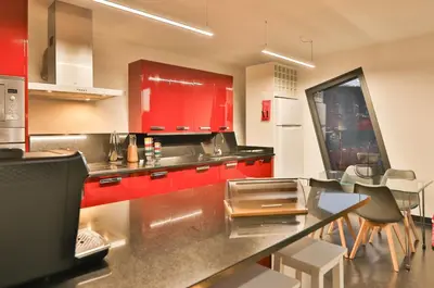 a kitchen with red cabinets and a counter top at Villa Leonor Cliffside Retreat in Calheta