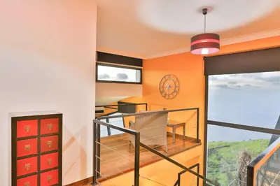 a room with a balcony with a view of the ocean at Villa Leonor Cliffside Retreat in Calheta