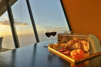 a table with a tray of food and two glasses of wine at Villa Leonor Cliffside Retreat in Calheta