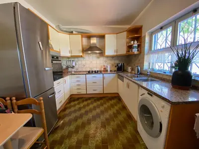 a kitchen with white cabinets and a washer at Casa Panorama in Salema