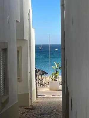 a view of the ocean from an alley way at Casa Panorama in Salema
