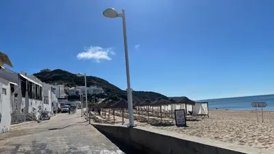 a street light on a beach next to the ocean at Casa Panorama in Salema