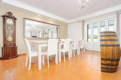 a dining room with a table and chairs and a clock at Casa Pereira – Snooker, Wi-Fi, Bbq, Pool in Relógio do Poiso