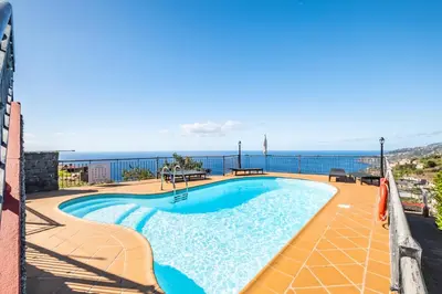 a swimming pool on top of a building with the ocean in the background at Vila Brava Cottage in Ribeira Brava