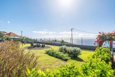 a park with a bench and a view of the ocean at Vila Brava Cottage in Ribeira Brava