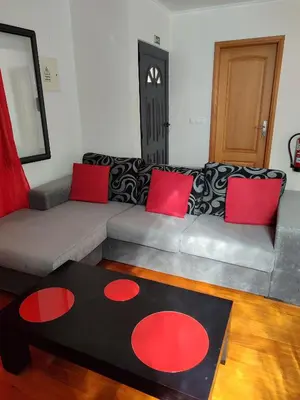a living room with a couch and a black and red rug at Delfina`s House in Machico