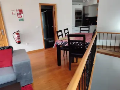 a living room with a table and chairs and a kitchen at Delfina`s House in Machico