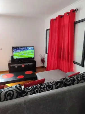 a living room with a couch and a flat screen tv at Delfina`s House in Machico
