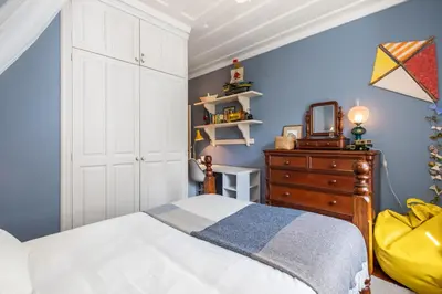 a bedroom with a bed and a dresser and a mirror at Casa Grande da Camélia in São Vicente