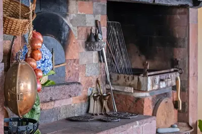 a kitchen with a brick oven with fruits and vegetables at Casa Grande da Camélia in São Vicente