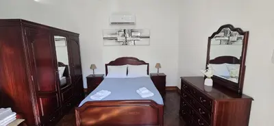 a bedroom with a bed and a dresser and a mirror at Fifty's House 2 By Sam Houses in Ribeira Brava