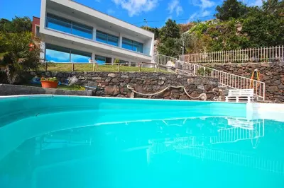 a swimming pool in front of a house at Villa Calçada in Santa Cruz