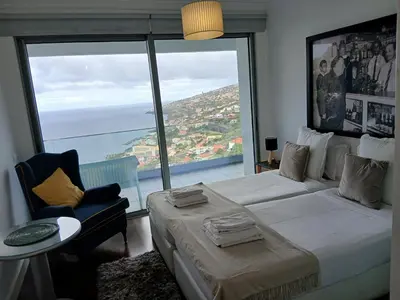 a bedroom with a large bed with a large window at Villa Calçada in Santa Cruz
