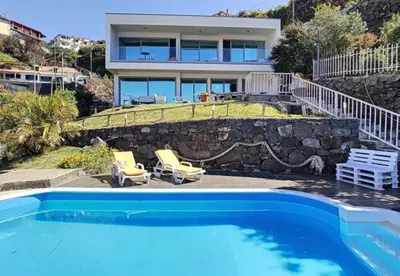 a house with a swimming pool in front of a house at Villa Calçada in Santa Cruz