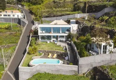 a patio with chairs and a table and the ocean at Villa Calçada in Santa Cruz