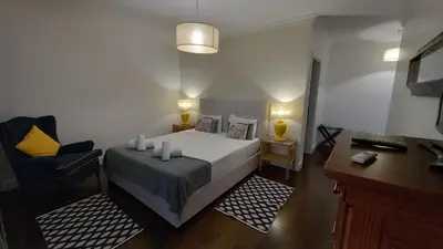 a bedroom with a bed with two lamps and a chair at Villa Calçada in Santa Cruz