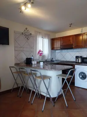 a kitchen with two chairs and a counter top at Casa Do Pico in São Vicente