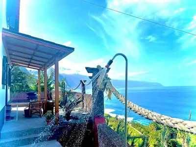 a patio of a house with a table and chairs at Casa Do Pico in São Vicente