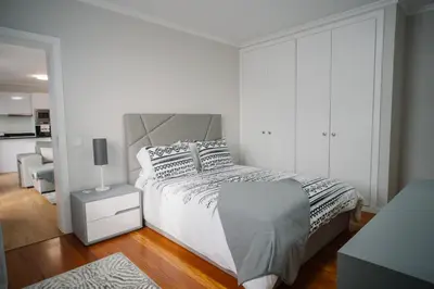 a white bedroom with a bed and a chair at casa são lourenço in Caniçal