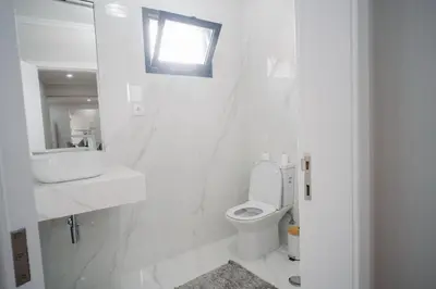 a white bathroom with a sink and a toilet at casa são lourenço in Caniçal