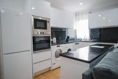 a white kitchen with a washer and dryer at casa são lourenço in Caniçal