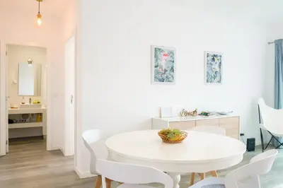 a white dining room with a white table and chairs at GuestReady - Cliff residence with sea views in Gaula