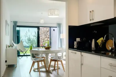 a white kitchen with a white table and chairs at GuestReady - Cliff residence with sea views in Gaula
