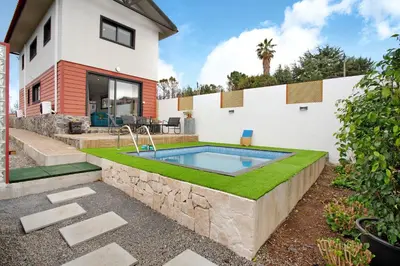 a patio with a table and chairs and a pool at Maravilha da Costa in Ponta do Pargo