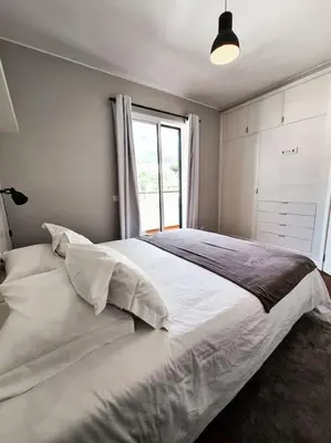 a bedroom with a large white bed with a window at Santa Luzia's Pearl III -Two Bedroom Apartment in Funchal