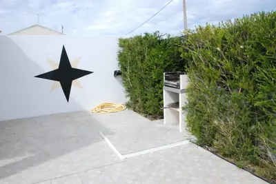 a wall with a star on it next to some bushes at Bonita Moradia c/ Piscina em SAGRES in Sagres