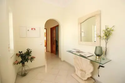 a hallway with a glass table and a mirror at Bonita Moradia c/ Piscina em SAGRES in Sagres