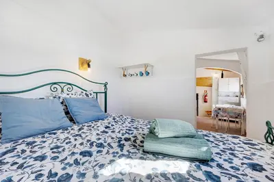 a bedroom with a bed with blue pillows on it at Abrigo do Pescador in Aljezur