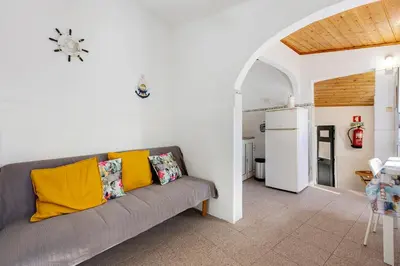 a living room with a gray couch with yellow pillows at Abrigo do Pescador in Aljezur