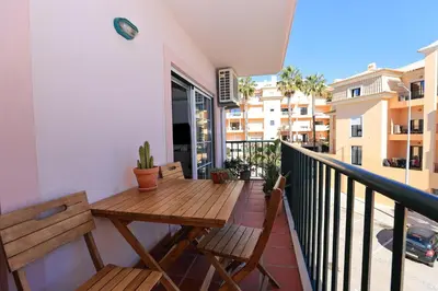 a balcony with a wooden table and benches at B95 - Casa Melo Apartment in Praia da Luz in Luz