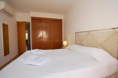 a bedroom with a white bed with two towels on it at B95 - Casa Melo Apartment in Praia da Luz in Luz