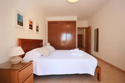 a bedroom with a white bed with a night stand and a lamp at B95 - Casa Melo Apartment in Praia da Luz in Luz