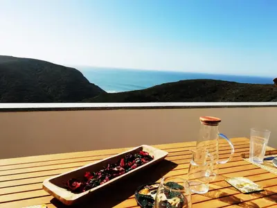 a wooden table with a tray of food on a balcony at Varandas Guest Apartment in Aljezur