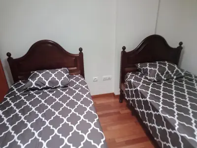 two beds sitting next to each other in a bedroom at Costa Lodges, Funchal or Santa Cruz in Santa Cruz