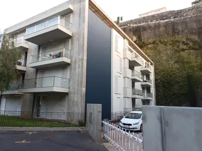 an apartment building with a car parked in front of it at Costa Lodges, Funchal or Santa Cruz in Santa Cruz