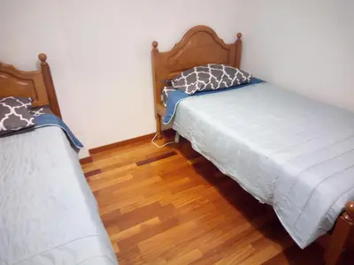 two beds in a room with wooden floors at Costa Lodges, Funchal or Santa Cruz in Santa Cruz