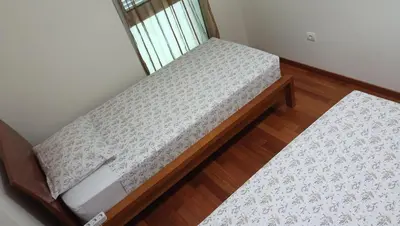 an empty bed in a room with a window at Costa Lodges, Funchal or Santa Cruz in Santa Cruz