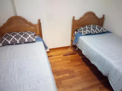two beds in a room with wooden floors at Costa Lodges, Funchal or Santa Cruz in Santa Cruz